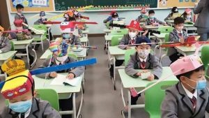 agrandeartedeserfeliz.com - Escola na China adota 'chapéu-helicóptero' para garantir distância entre alunos