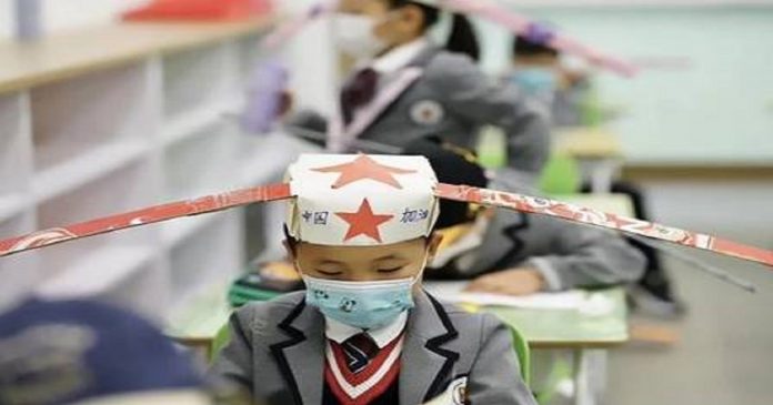 Escola na China adota ‘chapéu-helicóptero’ para garantir distância entre alunos